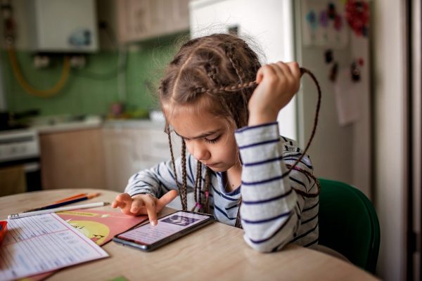 Pretty stylish schoolgirl studying math during her online lesson at home, social distance during quarantine, self-isolation, online education concept